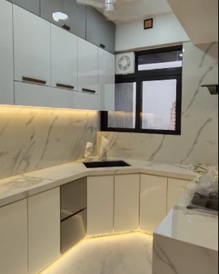 Marble-clad kitchen corner with warm under-cabinet lighting
